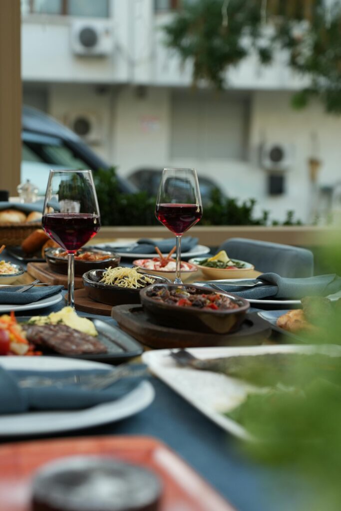 Sophisticated dining setup outdoors showcasing red wine and gourmet dishes in an elegant atmosphere.